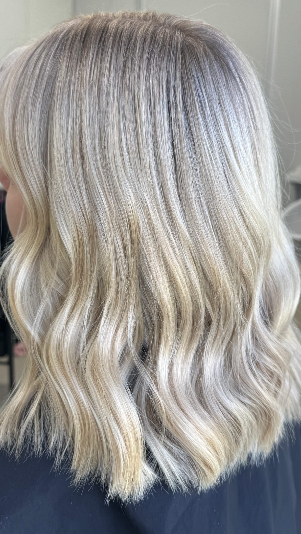Close-up of soft blonde waves with a shadowed root