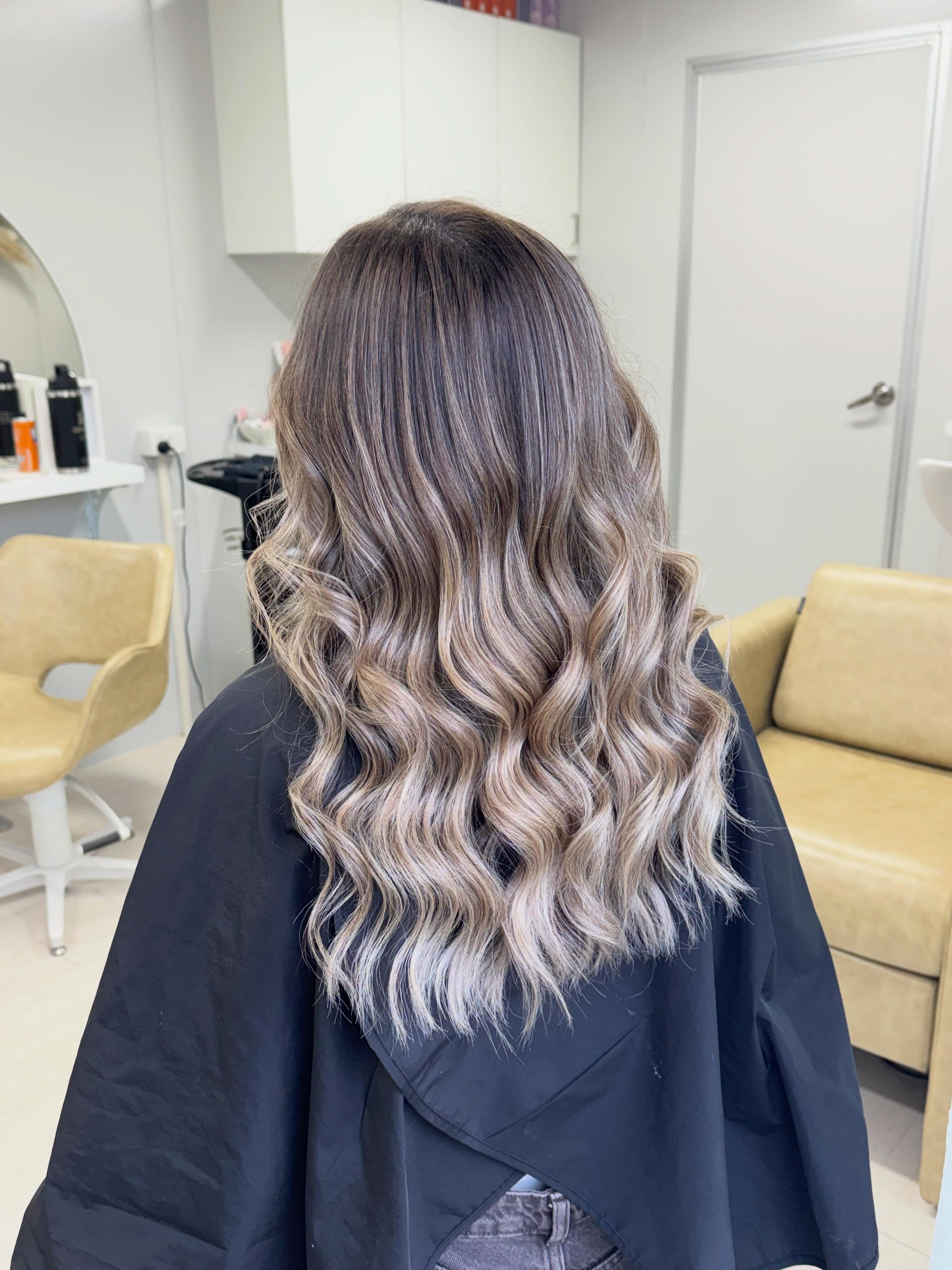 Long soft waves in a brunette-to-blonde blend, styled in the salon