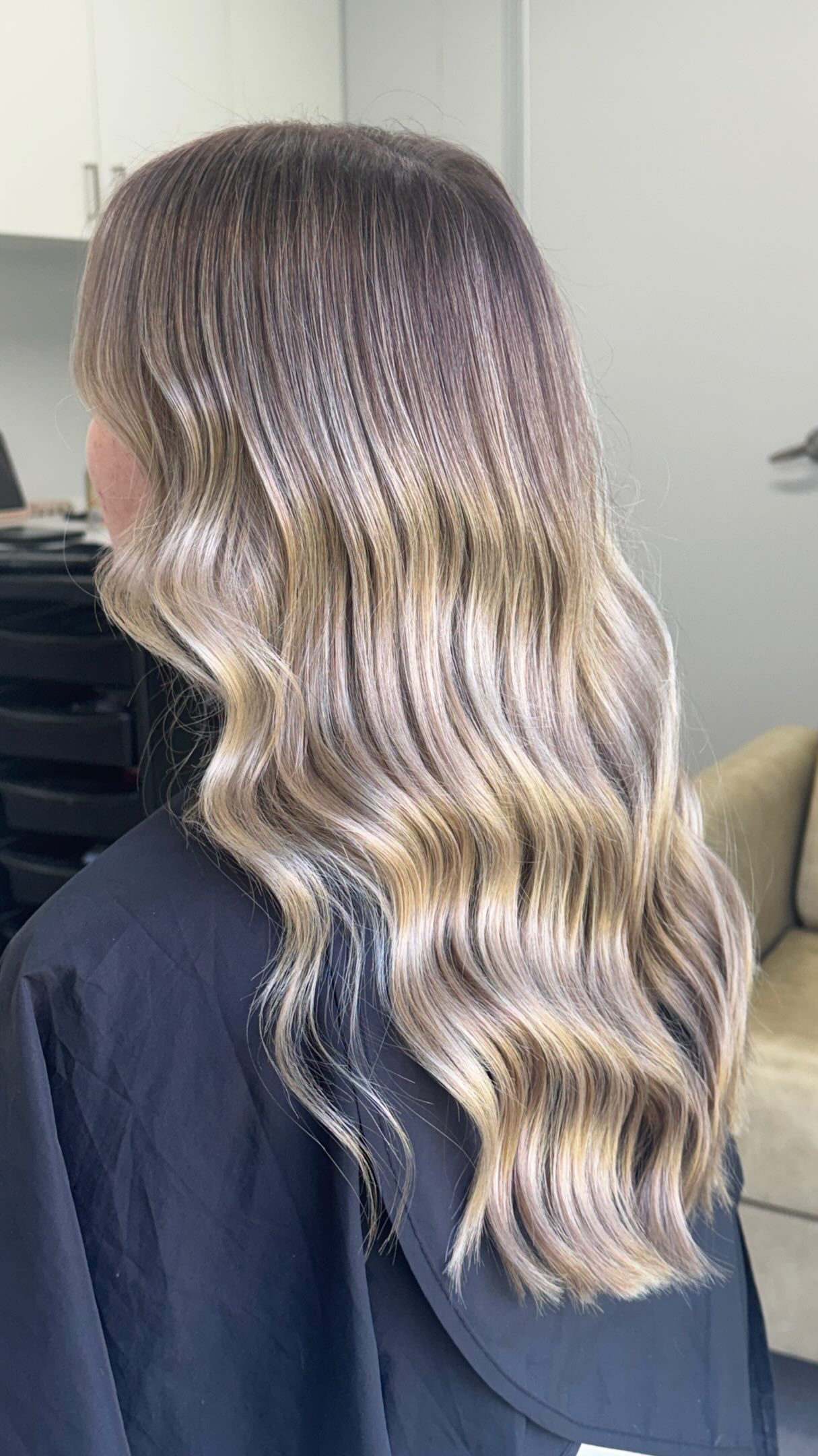 Side view of long, glossy blonde-highlighted waves